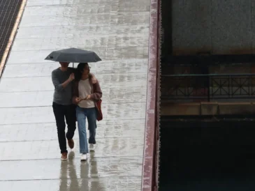 Dark rain clouds over downtown Chicago with umbrellas in a wet forecast
