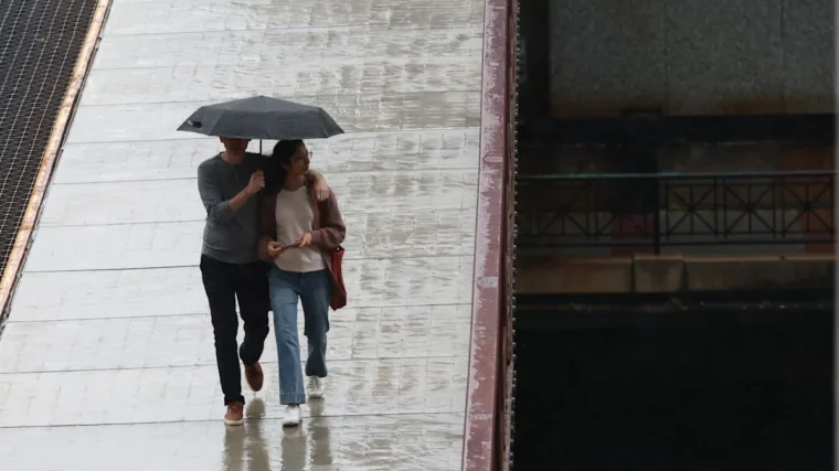 Dark rain clouds over downtown Chicago with umbrellas in a wet forecast