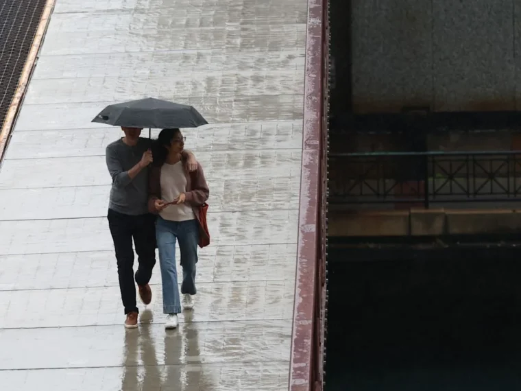Dark rain clouds over downtown Chicago with umbrellas in a wet forecast